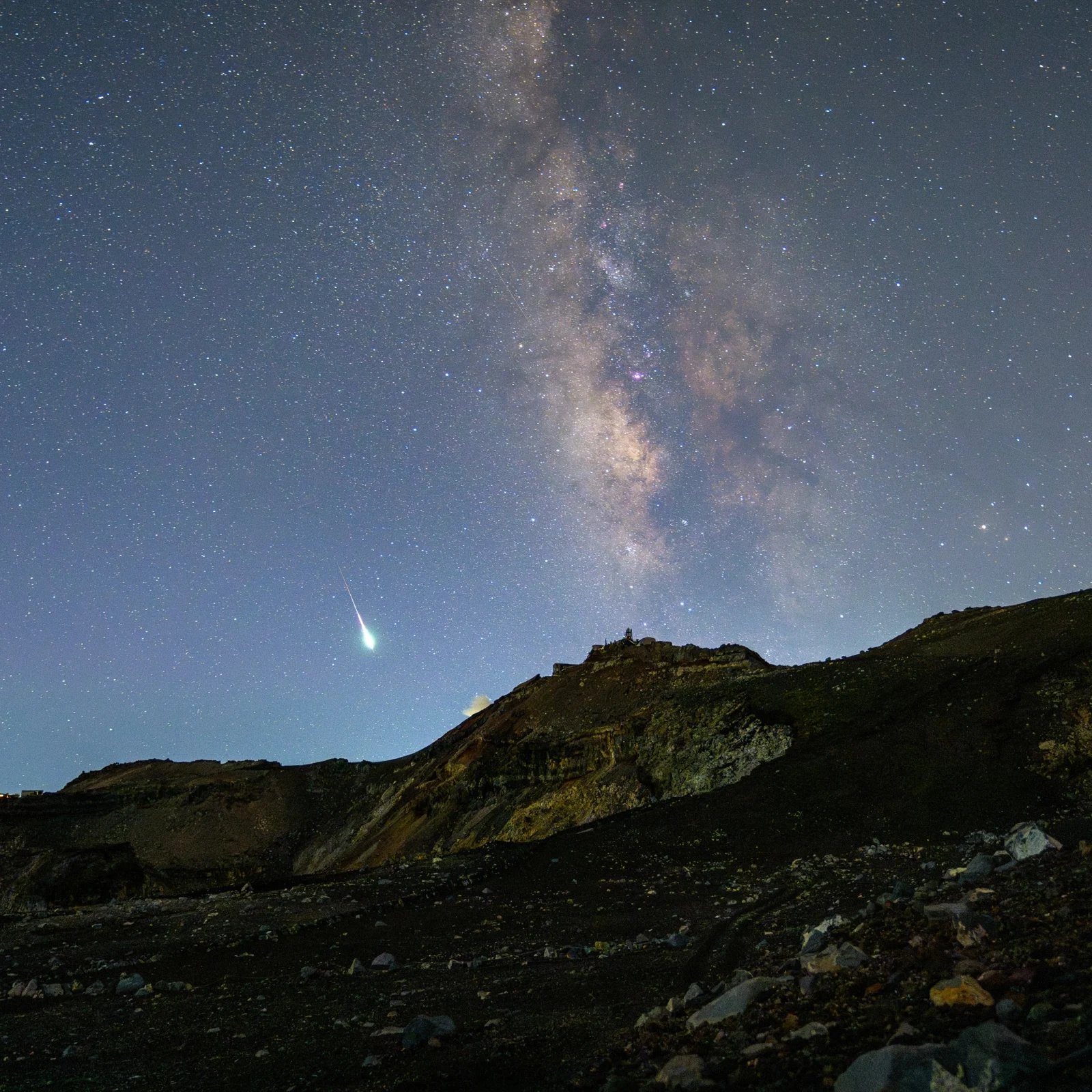 The Milky Way and a bright meteor above the rocky summit of Mt. Fuji